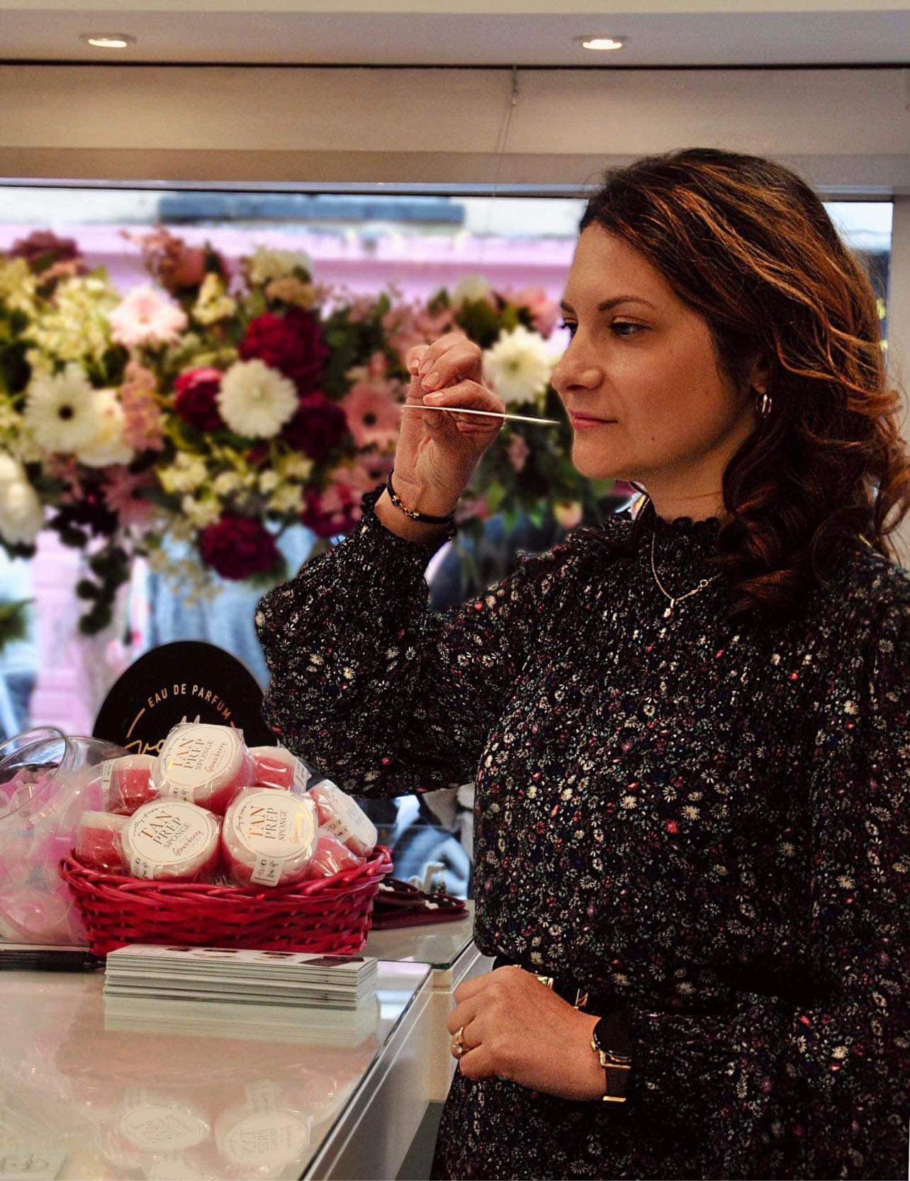 Woman enjoying fragrance, promoting EMBRACE SELF-LOVE: PERFUME RITUALS FOR RADIANT VIBES AND EMPOWERMENT at perfume shop.