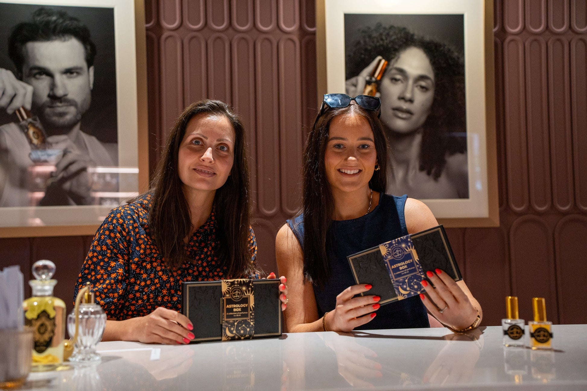 Small Group Bespoke Perfume Consultation with two women holding perfume sets at Valley of Roses, surrounded by elegant decor.