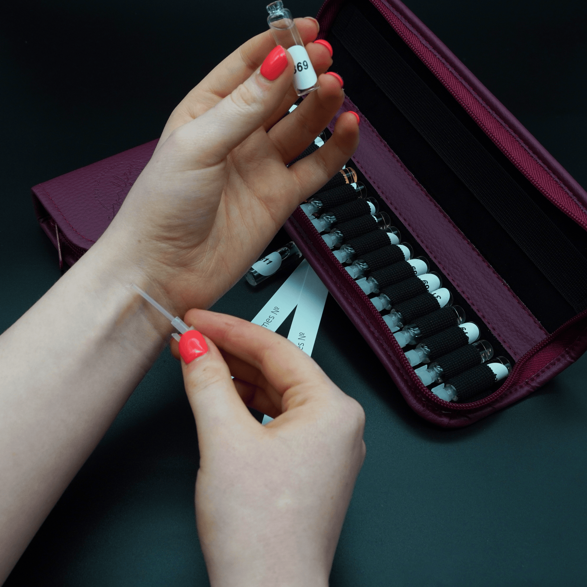 Discovery Kit Folder showcasing fragrance application process with perfume vial, revealing 40 scents in stylish case.